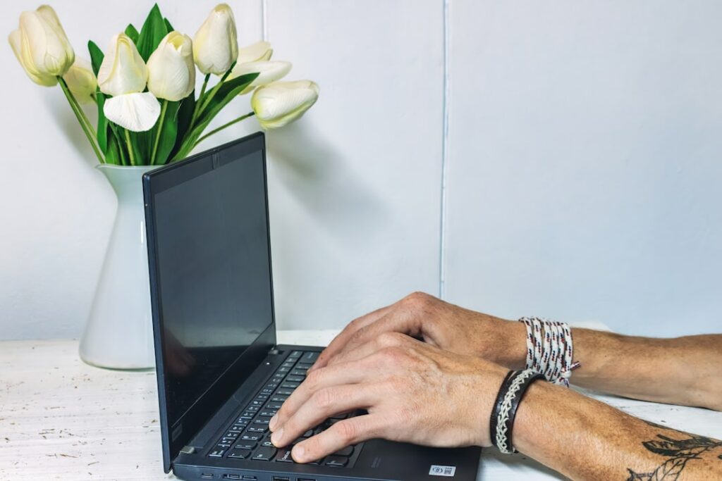 a man is typing on a laptop on a table