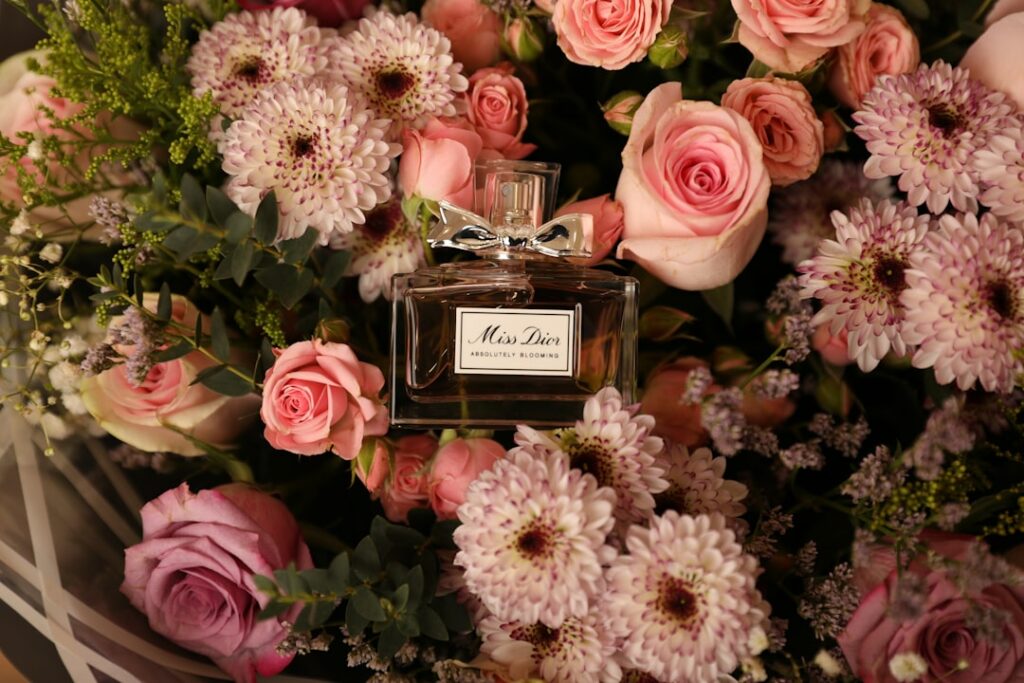 a bouquet of flowers with a bottle of perfume
